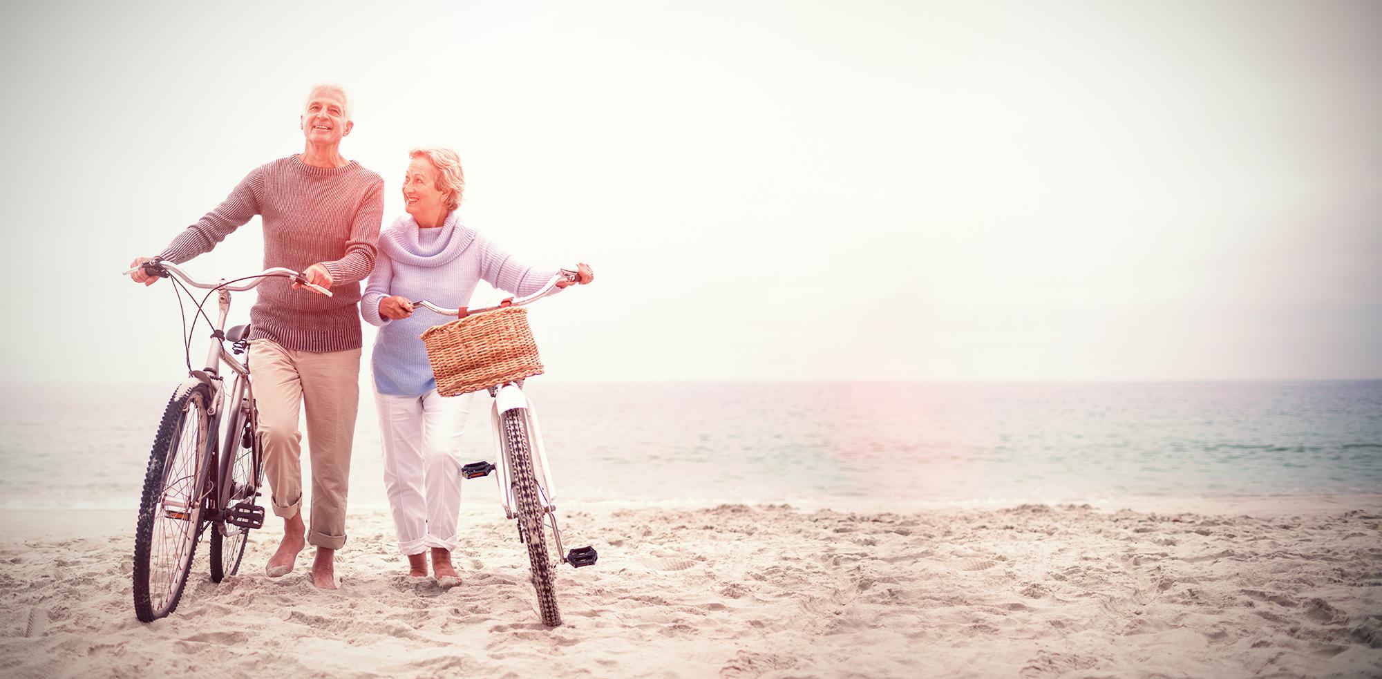 An older couple with bikes on the beach
