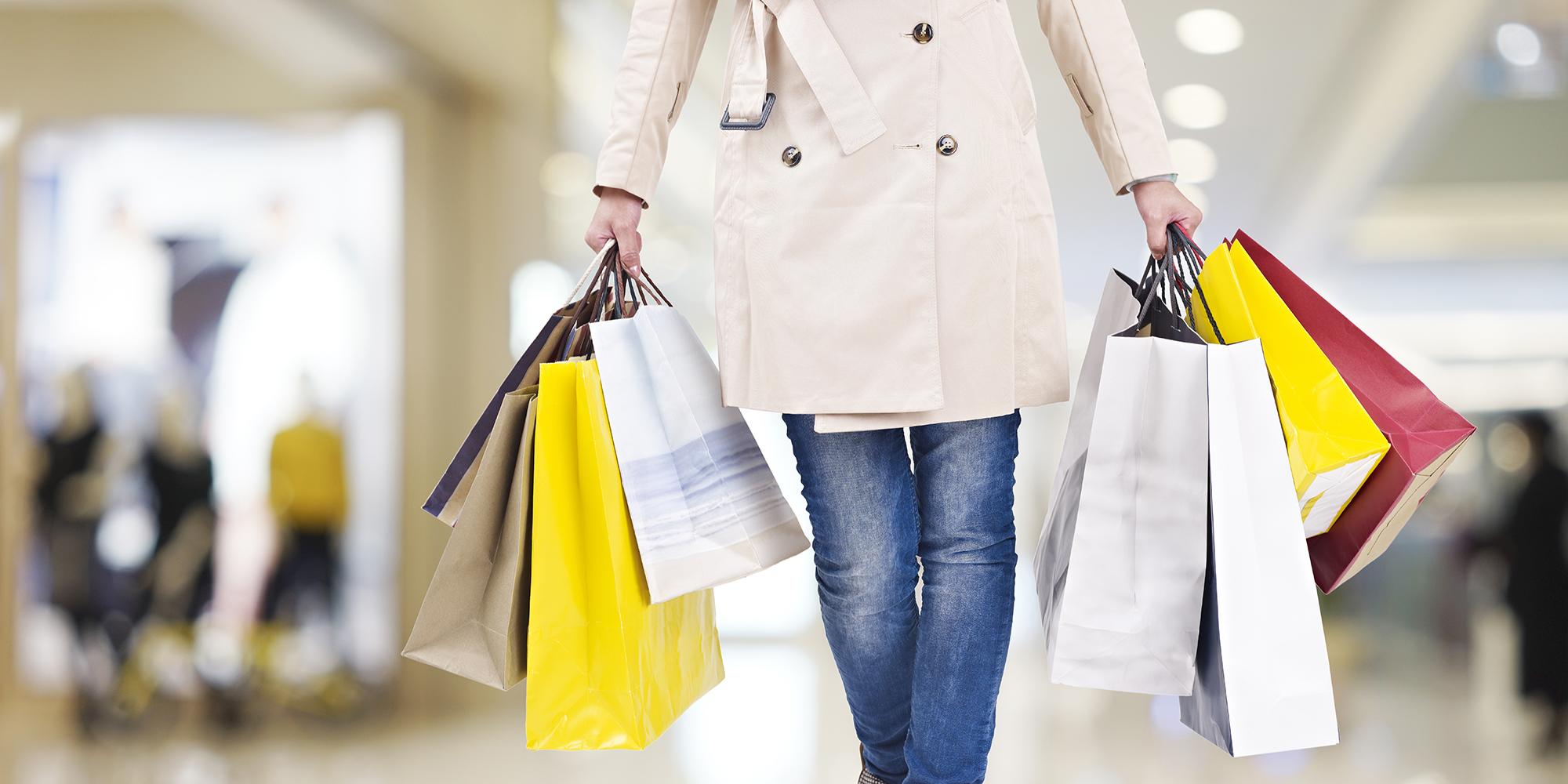 Une femme marchant dans un centre commercial avec des sacs de shopping