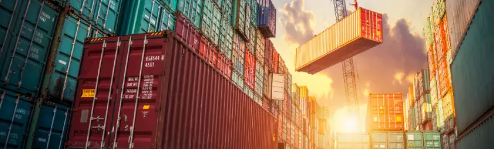 A truck is parked in front of a pile of containers.