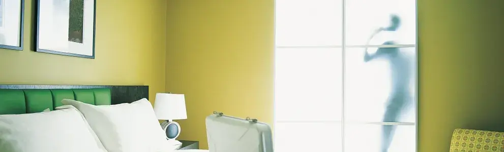 Suitcase lying on a bed in a hotel room.