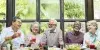 Un groupe de personnes âgées assises à une table avec de la nourriture.