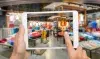 Une personne tenant une tablette avec une photo de vêtements affichée.