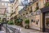 A street with tables and chairs in front of a building.